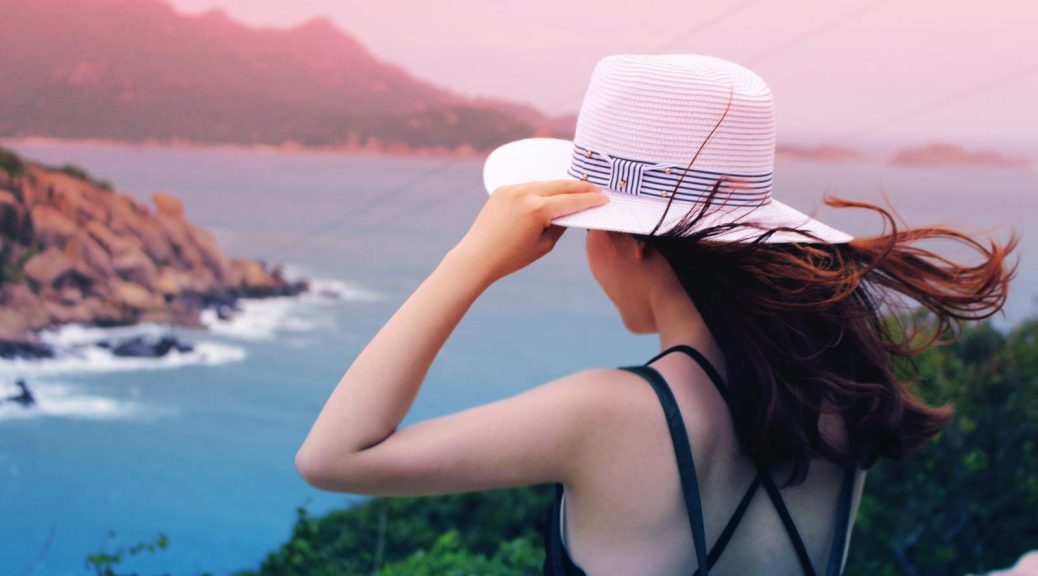 Wman Holding Wricker Shade Hat on Ocean View